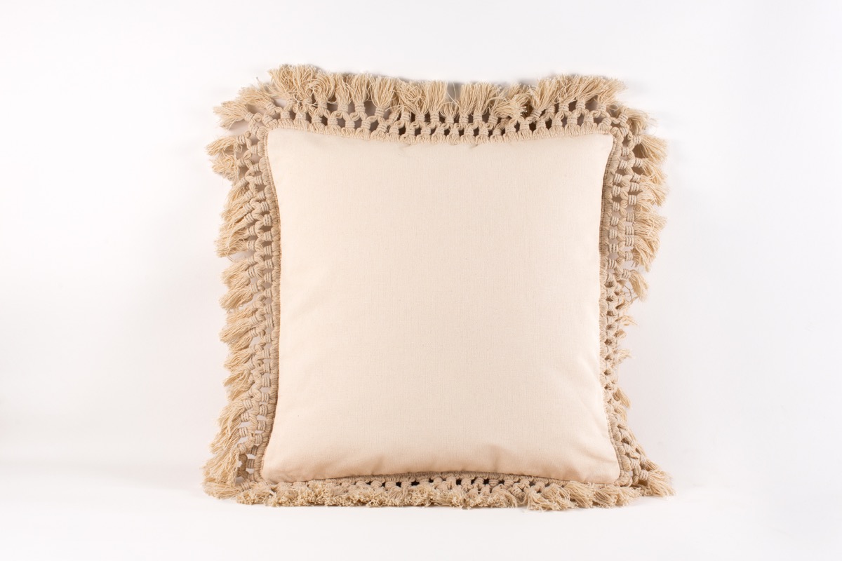 Cojín cuadrado beige con flecos decorativos de Teixits Vicens, diseño artesanal y neutro