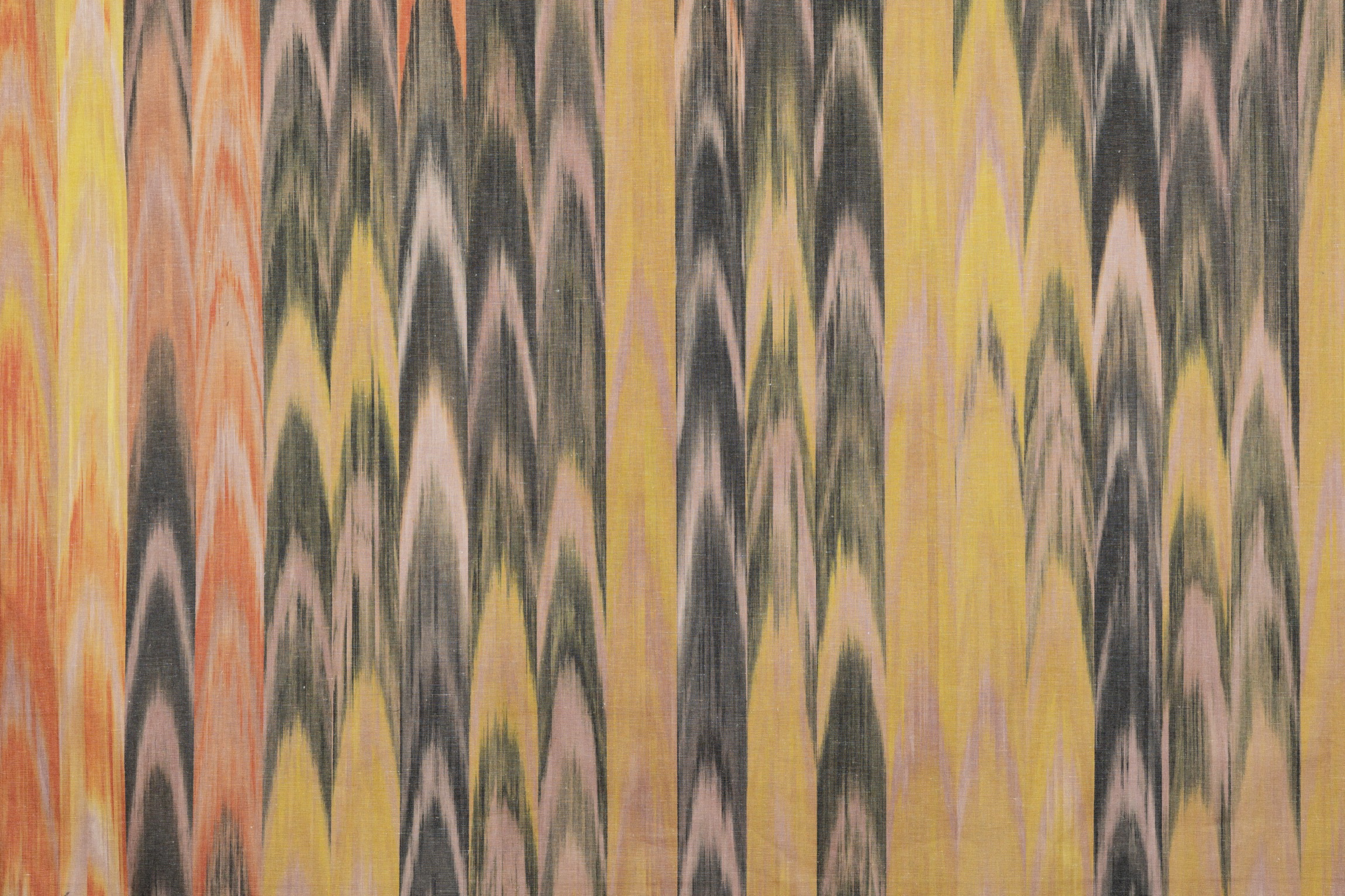 Tejido ikat mallorquín en tonos amarillos, naranjas y negros con patrón de lenguas tradicional