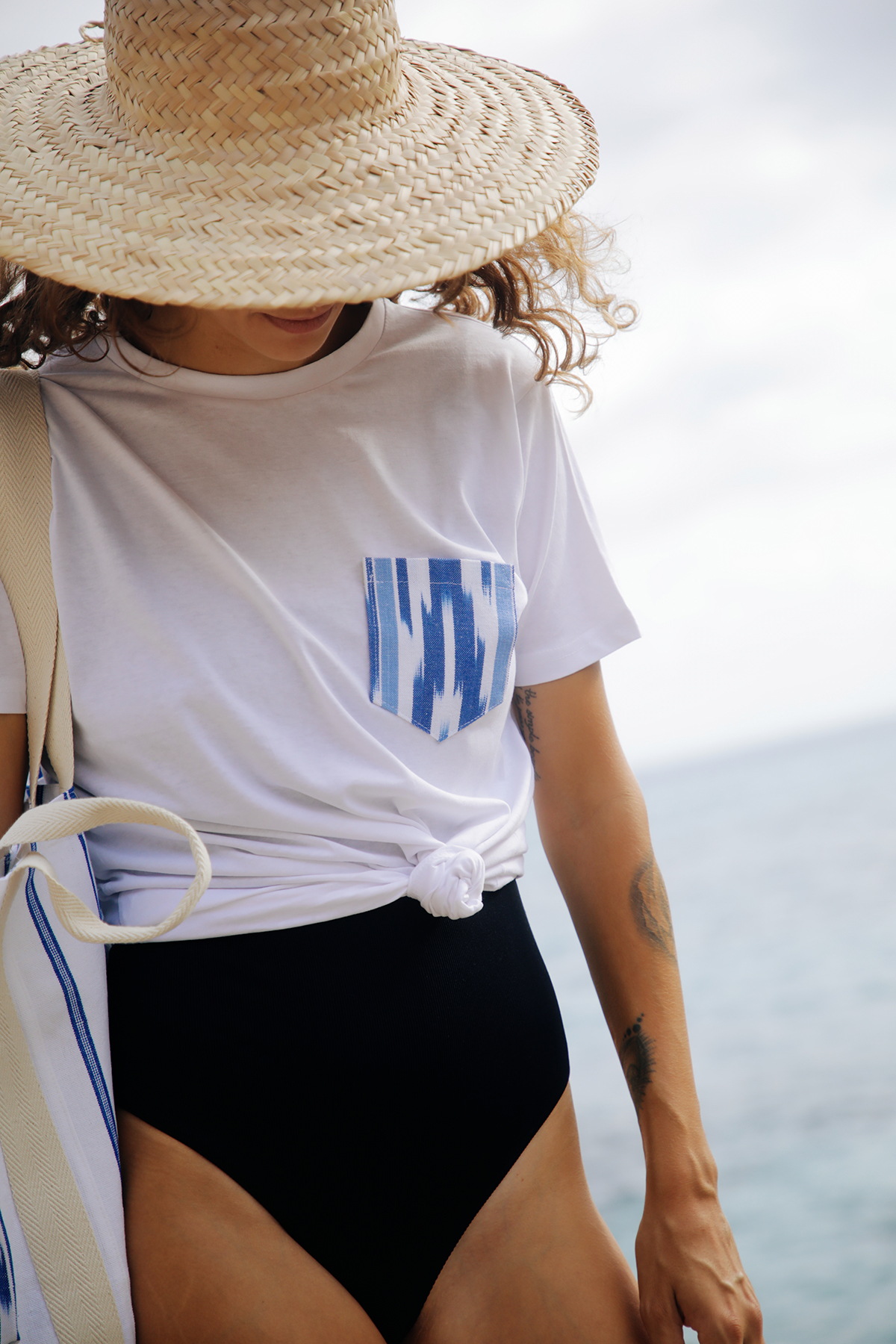 Modelo luciendo bolso artesanal de Teixits Vicens en entorno natural