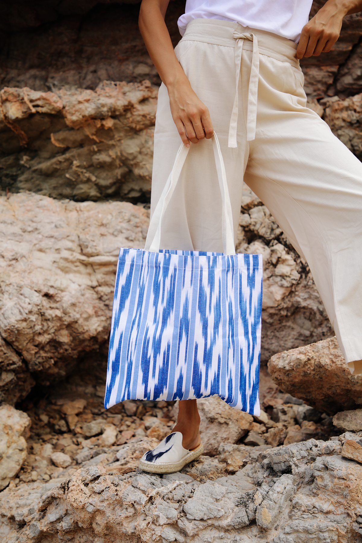 Modelo luciendo bolso artesanal de Teixits Vicens en entorno natural