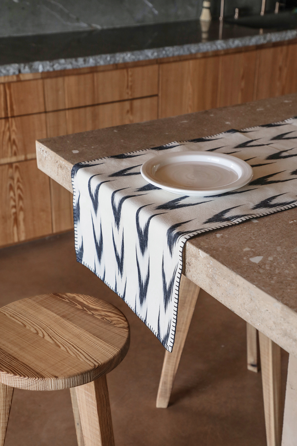 Camino de mesa de lino con estampado negro en forma de espiga sobre fondo blanco, ideal para decoración rústica